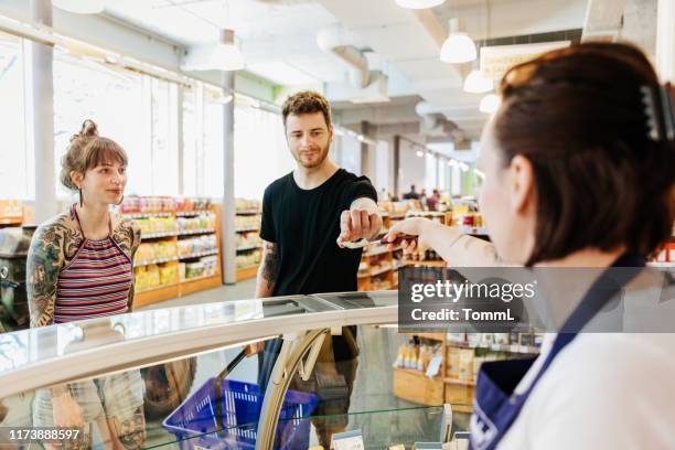 customers tasting sample at olive counter - trying stock pictures, royalty-free photos & images