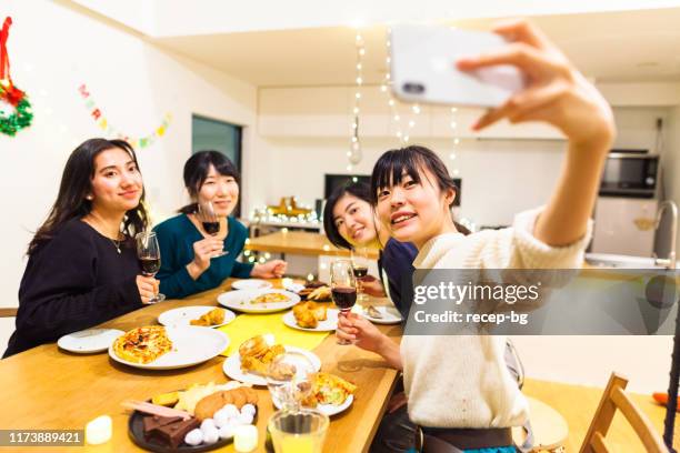 自宅でクリスマスディナーパーティーを持っている女性の友人 - home party ストックフォトと画像