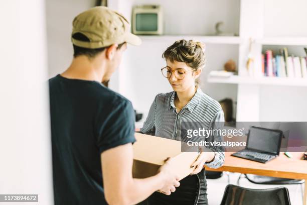 young entrepreneur receiving a package. - parcel laptop stock pictures, royalty-free photos & images