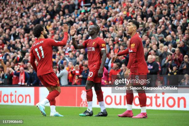 Sadio Mane of Liverpool celebrates with teammates Mohamed Salah of Liverpool and Roberto Firmino of Liverpool after scoring their 1st goal during the...