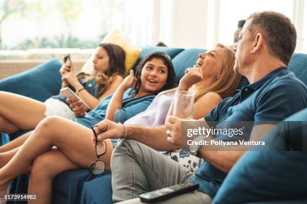 family watching tv - family on couch stock pictures, royalty-free photos & images