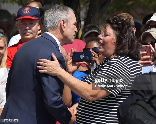 Former U.S. President George W. Bush greets Lisa Dolan, whose husband US Navy Capt. Robert Dolan was killed at the Pentagon, during a wreath-laying...