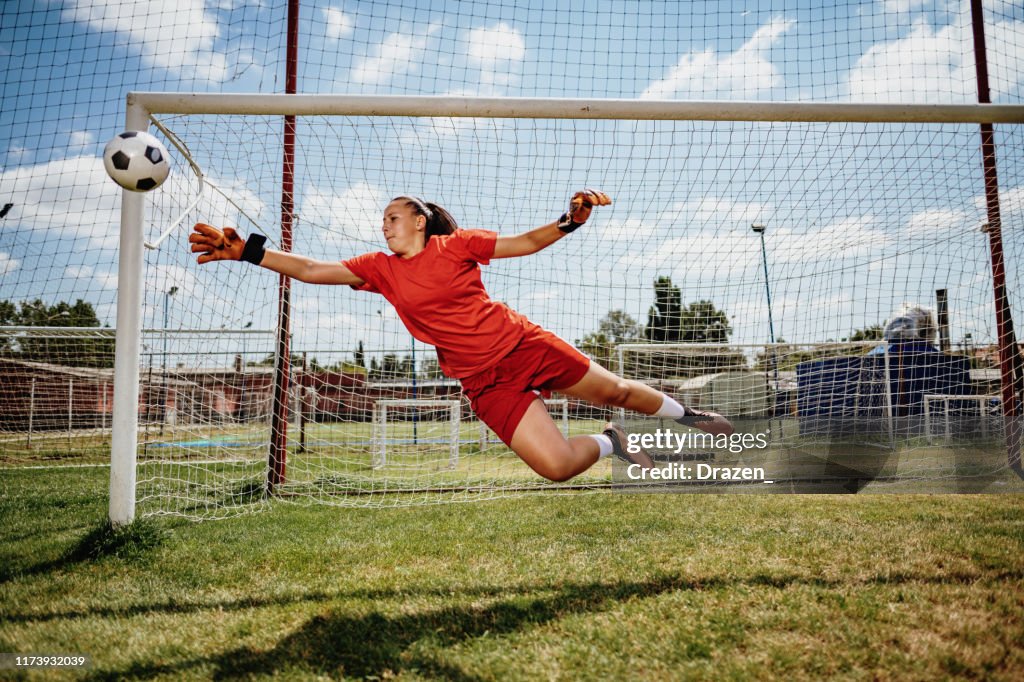 Soccer penalty kick with teen female goalkeeper