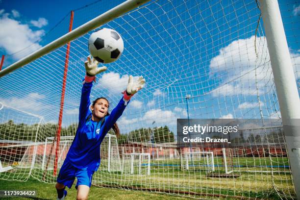 teenager goalkeeper playing soccer and defending penalty kicks - child goalie stock pictures, royalty-free photos & images