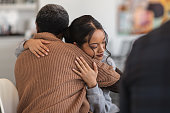 Supportive women hug while attending a group therapy session