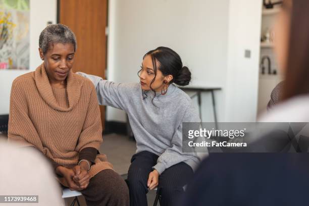 young woman shows support in therapy session - emotional support stock pictures, royalty-free photos & images