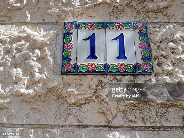 close-up of ornate street number, on house built with jerusalem stone - number 11 stock pictures, royalty-free photos & images