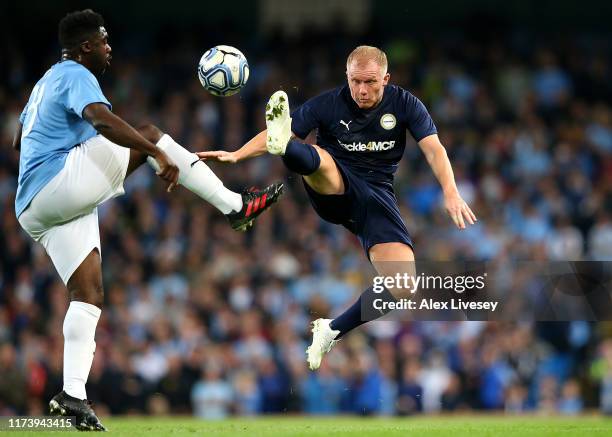 Paul Scholes of Premier League All-Starts XI tackles Kolo Toure of Manchester City Legends during the Vincent Kompany testimonial match between...