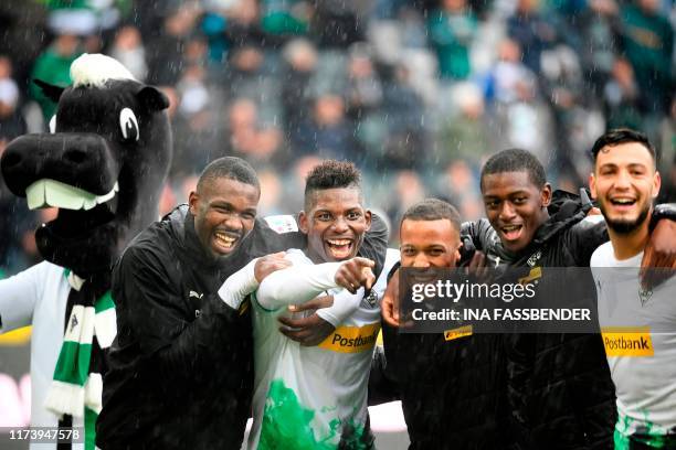 Moenchengladbach's French forward Marcus Thuram , Moenchengladbach's Swiss forward Breel Embolo and team mates celebrate the 5-1 victory after the...