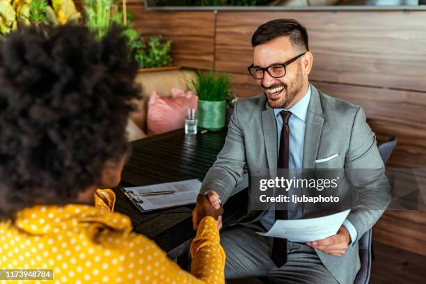 happy business colleagues in modern office - black business woman shaking hands stock pictures, royalty-free photos & images