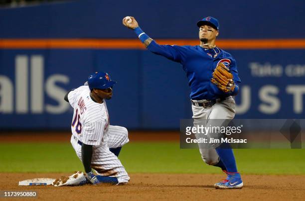 Javier Baez of the Chicago Cubs in action against Rajai Davis of the New York Mets at Citi Field on August 28, 2019 in New York City. The Cubs...