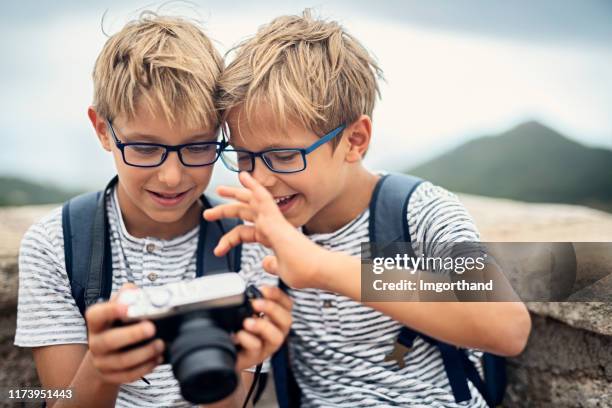 två små fotografer njuter av ny kamera. - twin bildbanksfoton och bilder