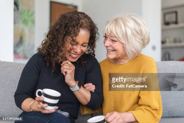 senior female friends having tea - baby boomer stock pictures, royalty-free photos & images