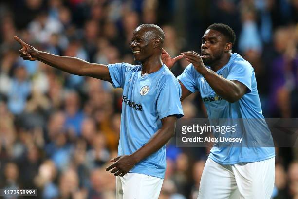 Benjani of Manchester City Legends celebrates with team mate Micah Richards after scoring a goal during the Vincent Kompany testimonial match between...