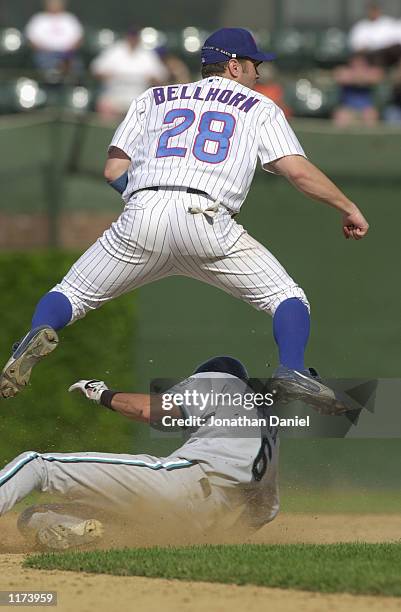 Second Baseman Mark Belhorn of the Chicago Cubs leaps over sliding shortstop Andy Fox of the Florida Marlins after his throw to first base to...