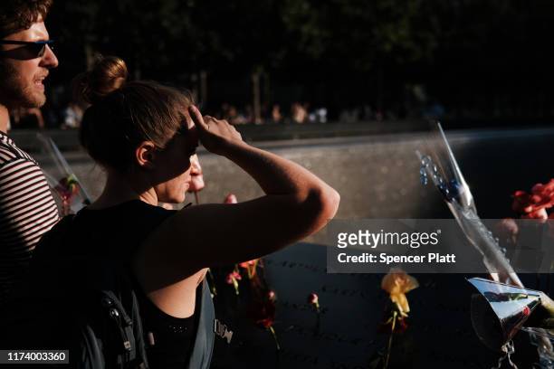 People gather at one of the pools at the National September 11 Memorial following a morning commemoration ceremony for the victims of the terrorist...