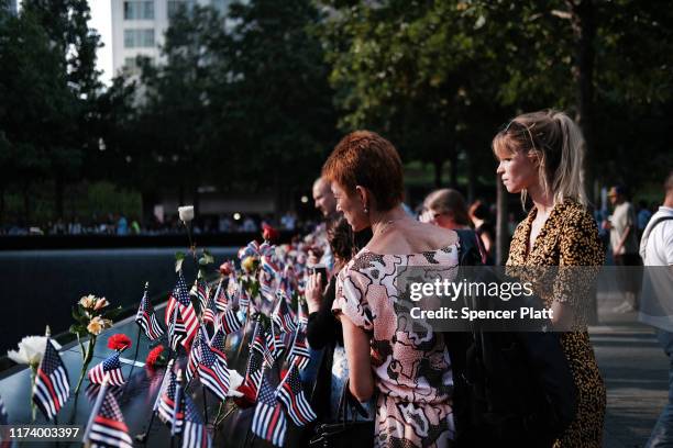 People gather at one of the pools at the National September 11 Memorial following a morning commemoration ceremony for the victims of the terrorist...