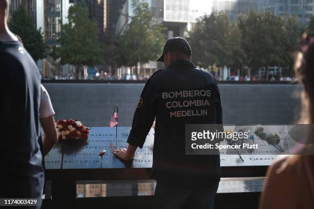 People gather at one of the pools at the National September 11 Memorial following a morning commemoration ceremony for the victims of the terrorist...