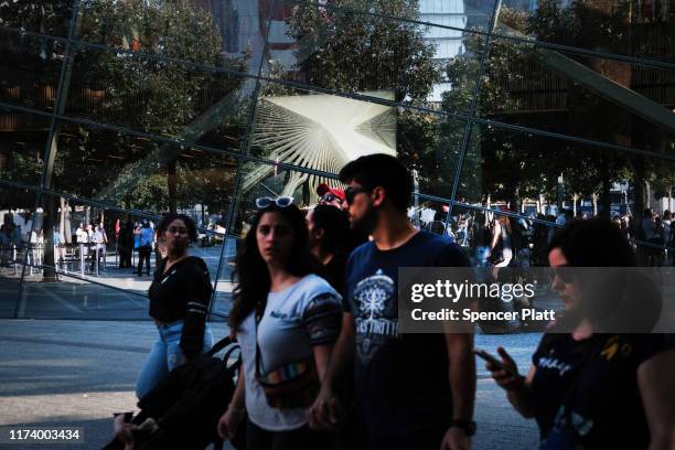 People gather at one of the pools at the National September 11 Memorial following a morning commemoration ceremony for the victims of the terrorist...