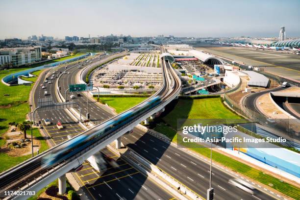 dubai international airport en metro op sunny day. - airport traffic stockfoto's en -beelden