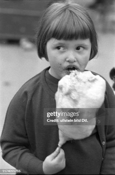 Mädchen isst Zuckerwatte am Jahrmarkt in Wohlen, 1965