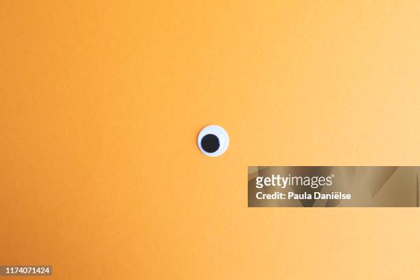 googly eye - fond orange photos et images de collection
