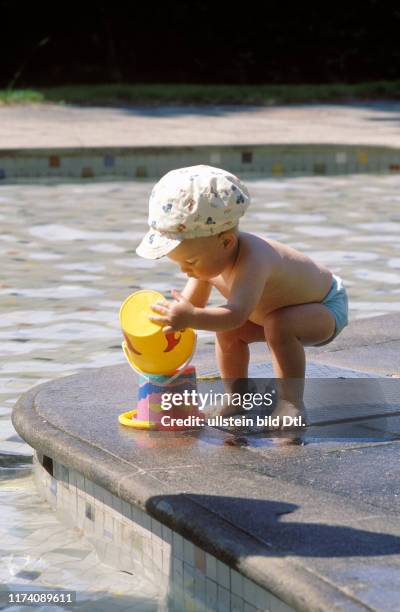 Kinder beim Spielen mit Eimer, Wasser beim Planschbecken