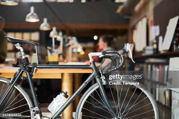 detalhe de uma bicicleta estacionada em um escritório de negócio novo. - estúdio de desenho gráfico - fotografias e filmes do acervo