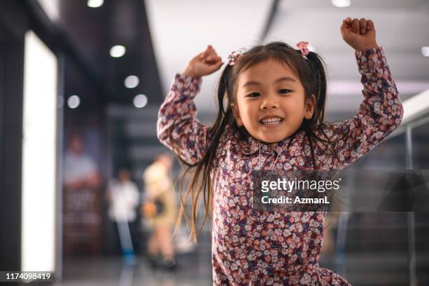 energetic young chinese girl with arms raised - children only stock pictures, royalty-free photos & images