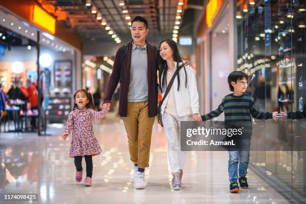 ontspannen jonge chinese familie winkelen in hong kong mall - hong kong family stockfoto's en -beelden