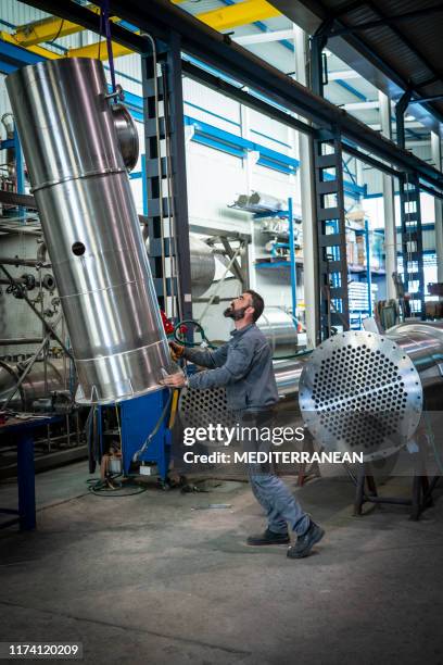 trabajador industrial moviéndose con grandes tuberías de grúa - industria pesada fotografías e imágenes de stock
