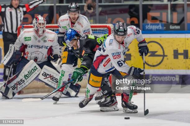 Florian Kettemer of Eisbaeren Berlin, Sahir Gill of Augsburger Panther and Sean Backman of Eisbaeren Berlin battle for the ball during the DEL match...