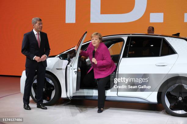 German Chancellor Angela Merkel gets out of a Volkswagen ID.3 electric car as Association of German Auto Industry head Bernhard Mattes looks on...