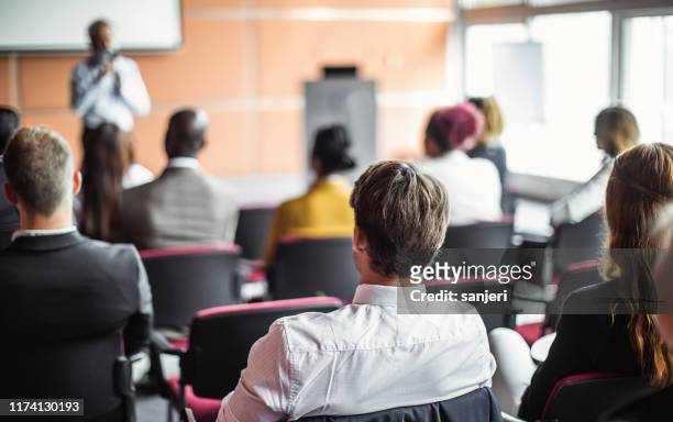 uomini d'affari a una conferenza ascoltando lo speaker - participant foto e immagini stock