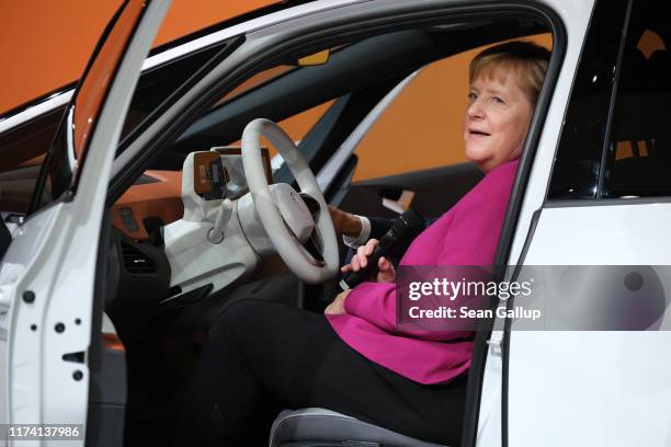 German Chancellor Angela Merkel sits in a Volkswagen ID.3 electric car during a tour of exhibition halls on the opening day of the IAA 2019 Frankfurt...