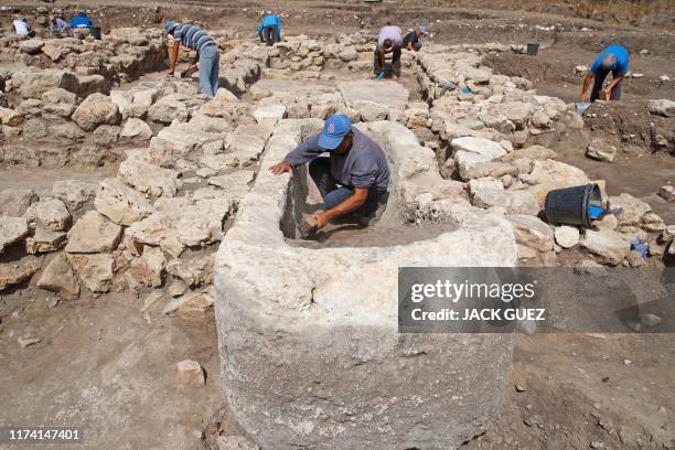 Israeli workers unearth stone structures including a basin believed to be proof of sacrificial offerings at the archaeological site of En Esur where...