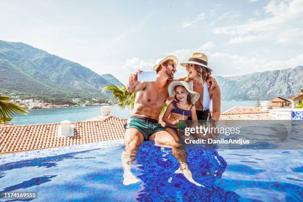 beautiful family take selfie in a swimming pool - family holidays hotel stock pictures, royalty-free photos & images