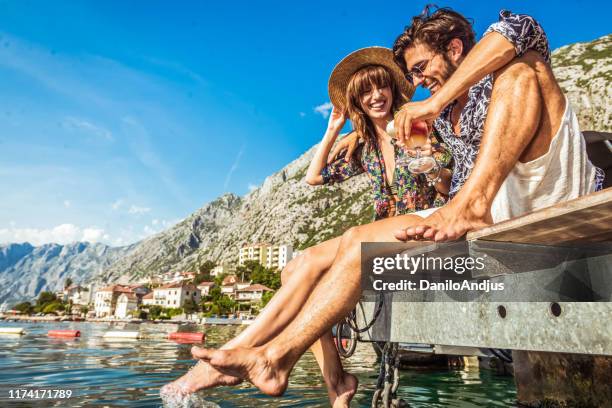 young loving couple drink cocktails by the sea - montenegro stock pictures, royalty-free photos & images