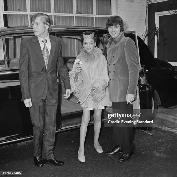 American actress and singer Judy Garland stands with her 5th husband to be Mickey Deans and best man Johnnie Ray beside their limousine car on the...