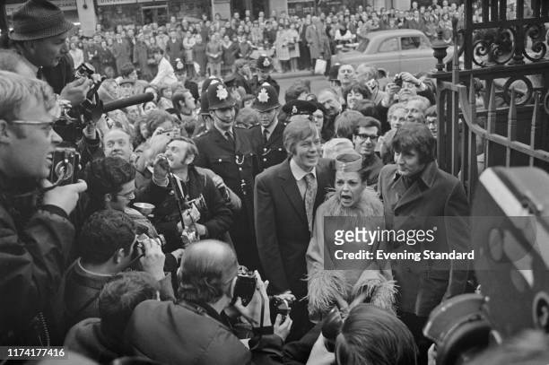 American singer and actress Judy Garland , new 5th husband to be Mickey Deans and best man Johnnie Ray , surrounded by crowds of onlookers and police...