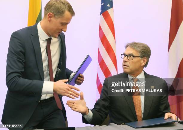 Lithuanian Minister of Energy Zygimantas Vaiciunas shakes hands with US Secretary of Energy Rick Perry after signing an agreement on strengthening...