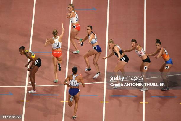 Athletes wait to receive the baton as they compete in the Women's 4x400m Relay final at the 2019 IAAF Athletics World Championships at the Khalifa...