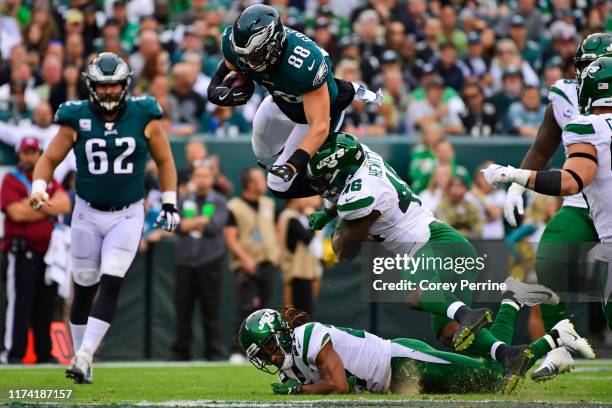Dallas Goedert of the Philadelphia Eagles is upended by Neville Hewitt of the New York Jets as Darryl Roberts of the Jets lies on the turf during the...