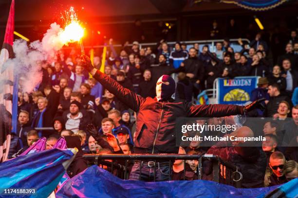 Djurgardens IF supporter holds a flare during an Allsvenskan match between Djurgardens IF and Hammarby IF at Tele2 Arena on October 6, 2019 in...