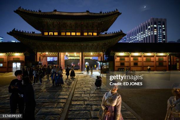 In a photo taken on October 4 people visit during a night opening at Gyeongbokgung palace in central Seoul.