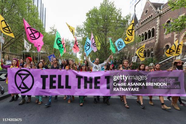 Demonstrators march on a street during a Extinction Rebellion protest in Melbourne on October 7, 2019. Extinction Rebellion activists began gathering...