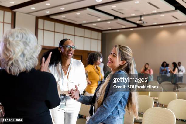 businesswomen laugh together during seminar - town hall meeting stock pictures, royalty-free photos & images