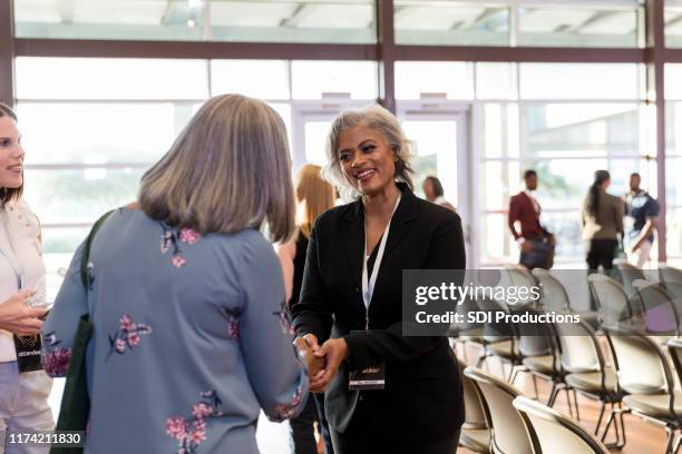 conference speaker greets guest - voting district stock pictures, royalty-free photos & images