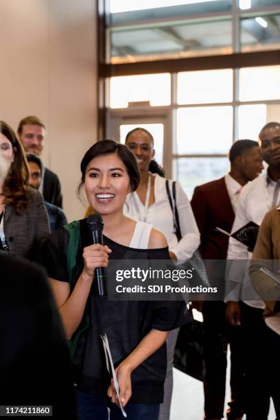 excited woman asks a question during business conference - diverse town hall meeting stock pictures, royalty-free photos & images