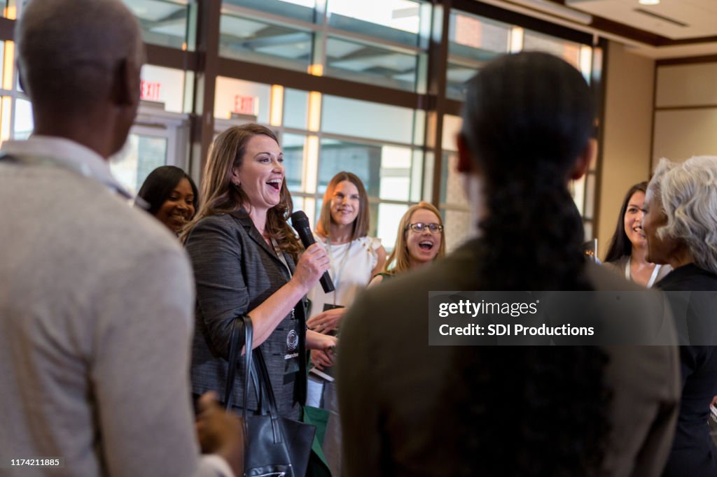 Cheerful woman ask question during town hall meeting